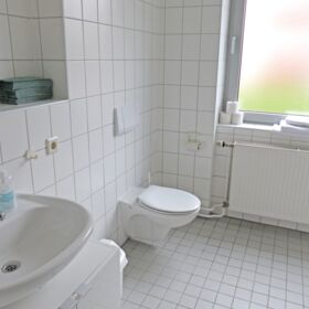 Badezimmer mit weißen Fliesen